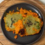 Moong Dal Shakshuka topped with curry leaf tadka in a skillet