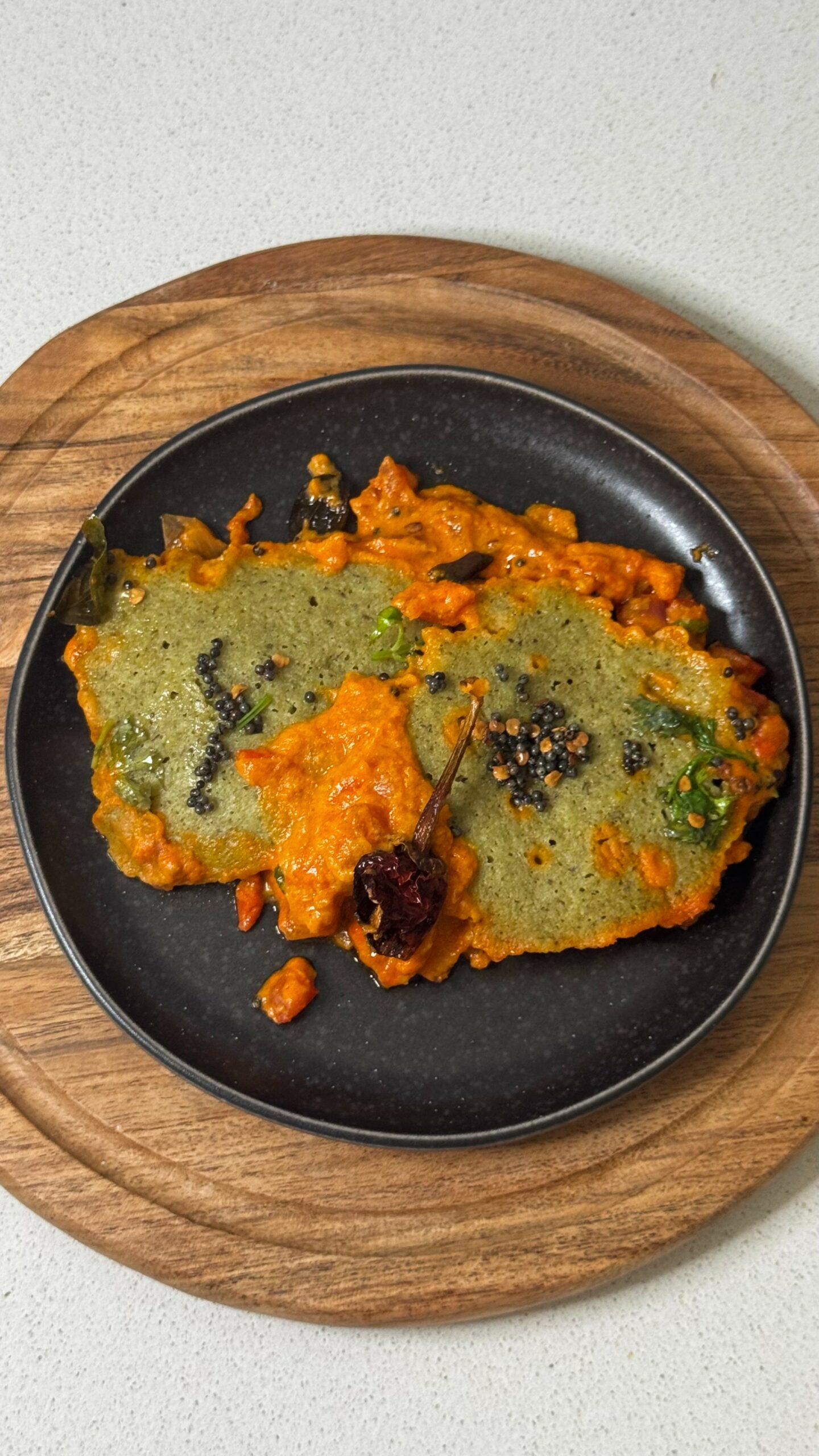 Moong Dal Shakshuka topped with curry leaf tadka in a skillet