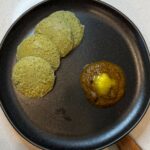 Soft high-protein sprouts idli served with spicy tomato dal chutney and melted ghee