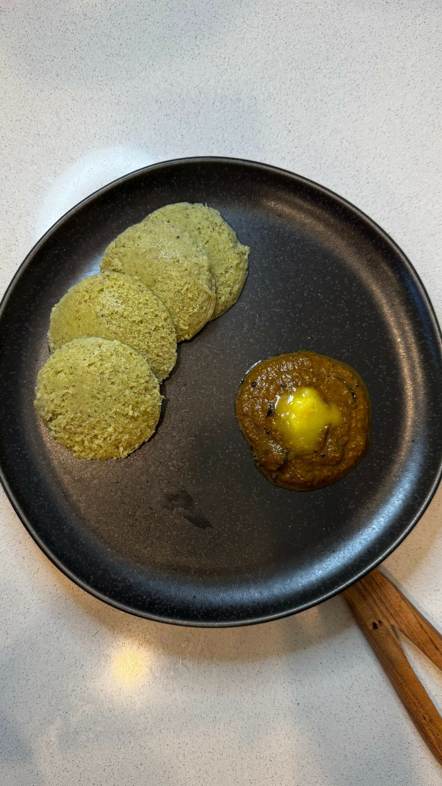 Soft high-protein sprouts idli served with spicy tomato dal chutney and melted ghee