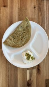 Crispy whole moong cheela served with a bowl of creamy Greek yogurt