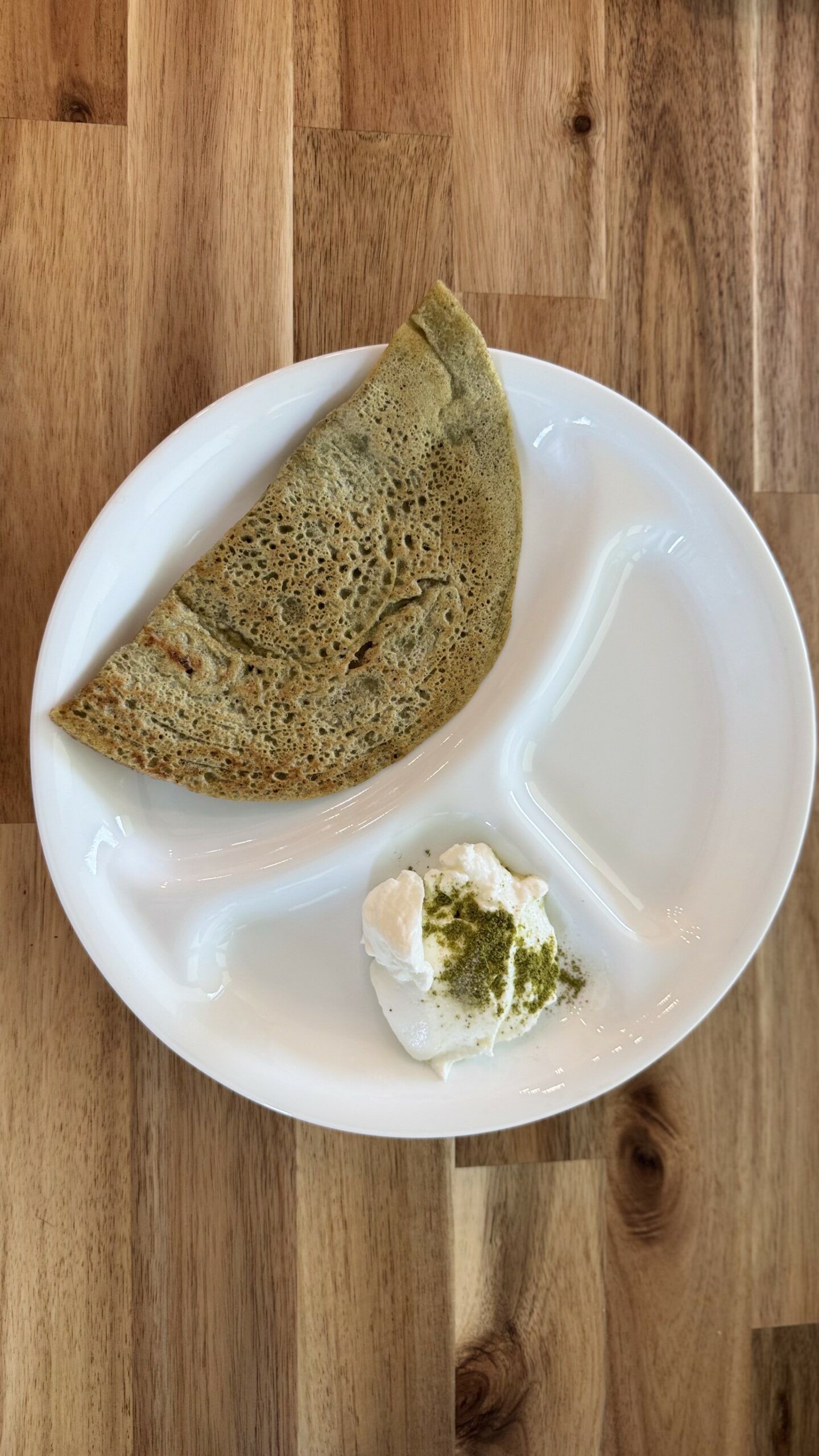 Crispy whole moong cheela served with a bowl of creamy Greek yogurt