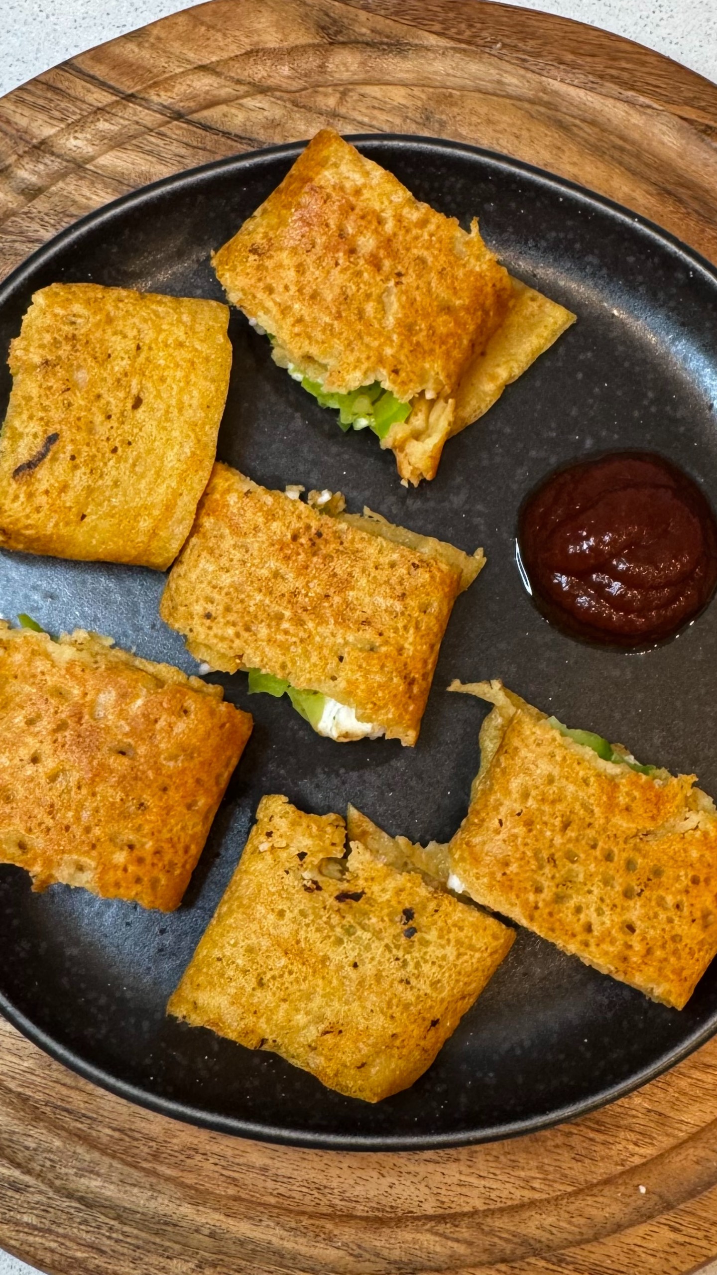 Crispy paneer moong dal wrap sliced on a plate